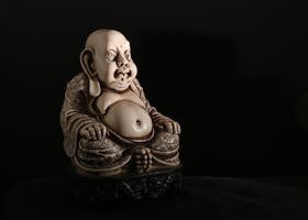 A detailed Buddha sculpture in dim lighting, embodying serenity and ancient art.