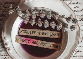 Flat lay of a teacup with lavender and an inspirational message, set against cursive text background.