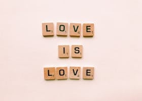 Wooden letter tiles forming 'Love is Love', symbolizing inclusion and pride.